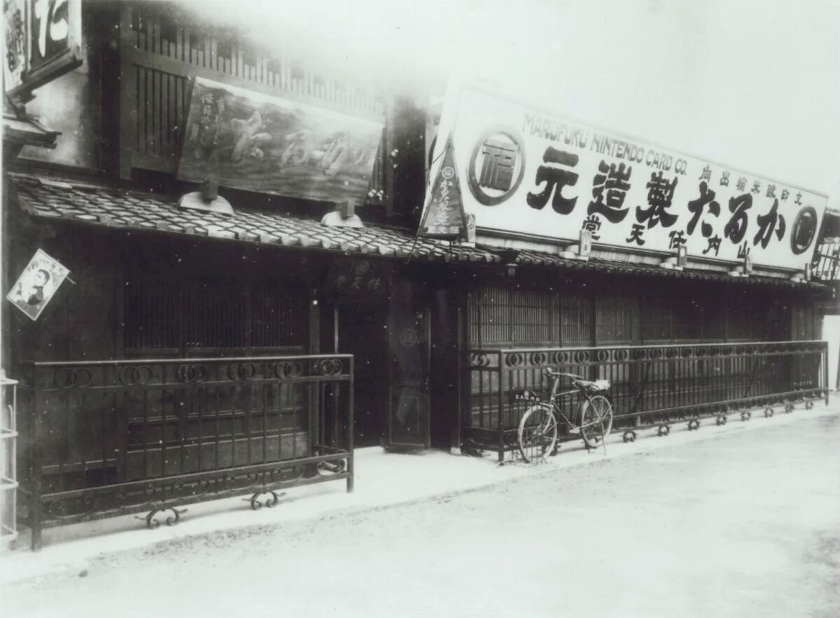 A wooden storefront with wrought-iron railings and a bicycle parked outside.