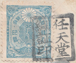 A square blue tax stamp reading ‘50 sen’ in Japanese with a stylized chrysanthemum flower. The stamp is overprinted with black ink reading ‘Nintendo’ in Japanese.