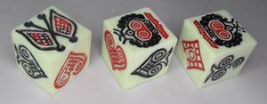 Three dice bearing the symbols of the flag, crown, and playing card symbols, in elaborate carvings.