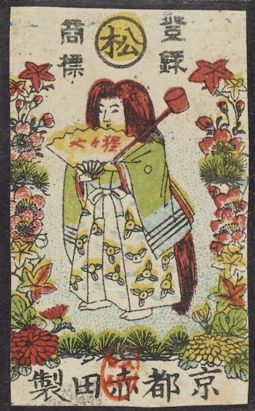 A card with an image of a woman carrying a fan with the manufacturer’s name written upon it, surrounded by leaves of the various plants of the Hanafuda deck