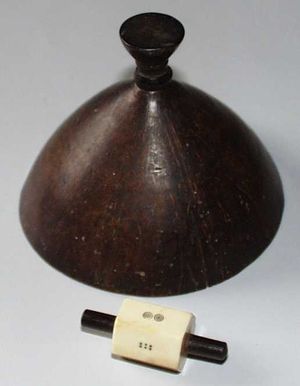 A wooden dice cover and six-sided teetotum.