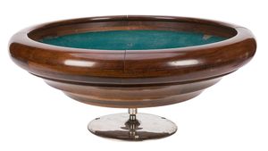 A wooden bowl mounted on a spindle and lined with green baize.