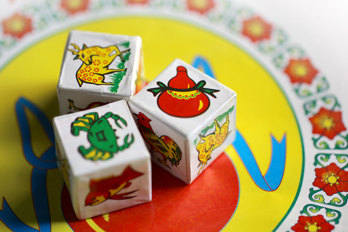 Three dice, showing a deer, crab, and gourd.