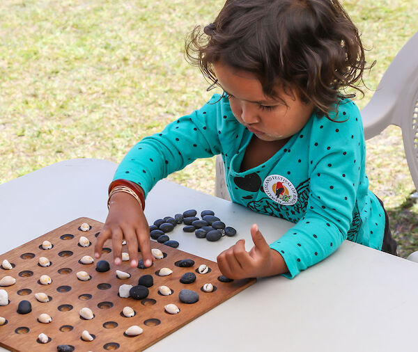 A child playing kōnane.