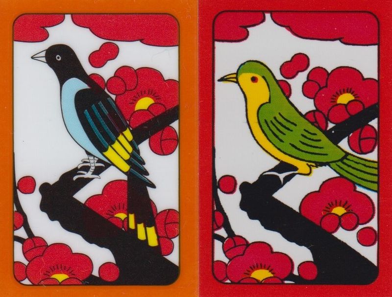 Two hwatu-format cards: the left shows cherry blossoms with a Korean magpie that has a blue chest with black and yellow wings, while the right shows cherry blossoms with a lesser cuckoo that has a yellow body and green wings.